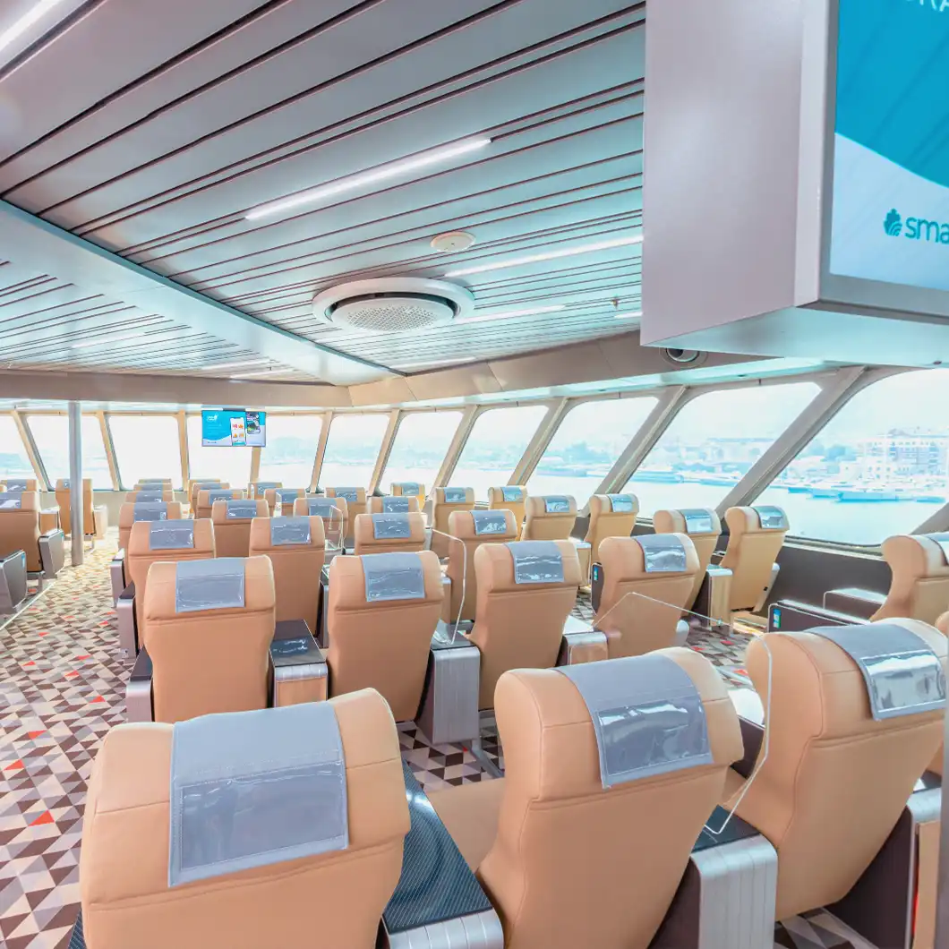 Passengers viewing travel information and entertainment content on digital screens in the lounge area.