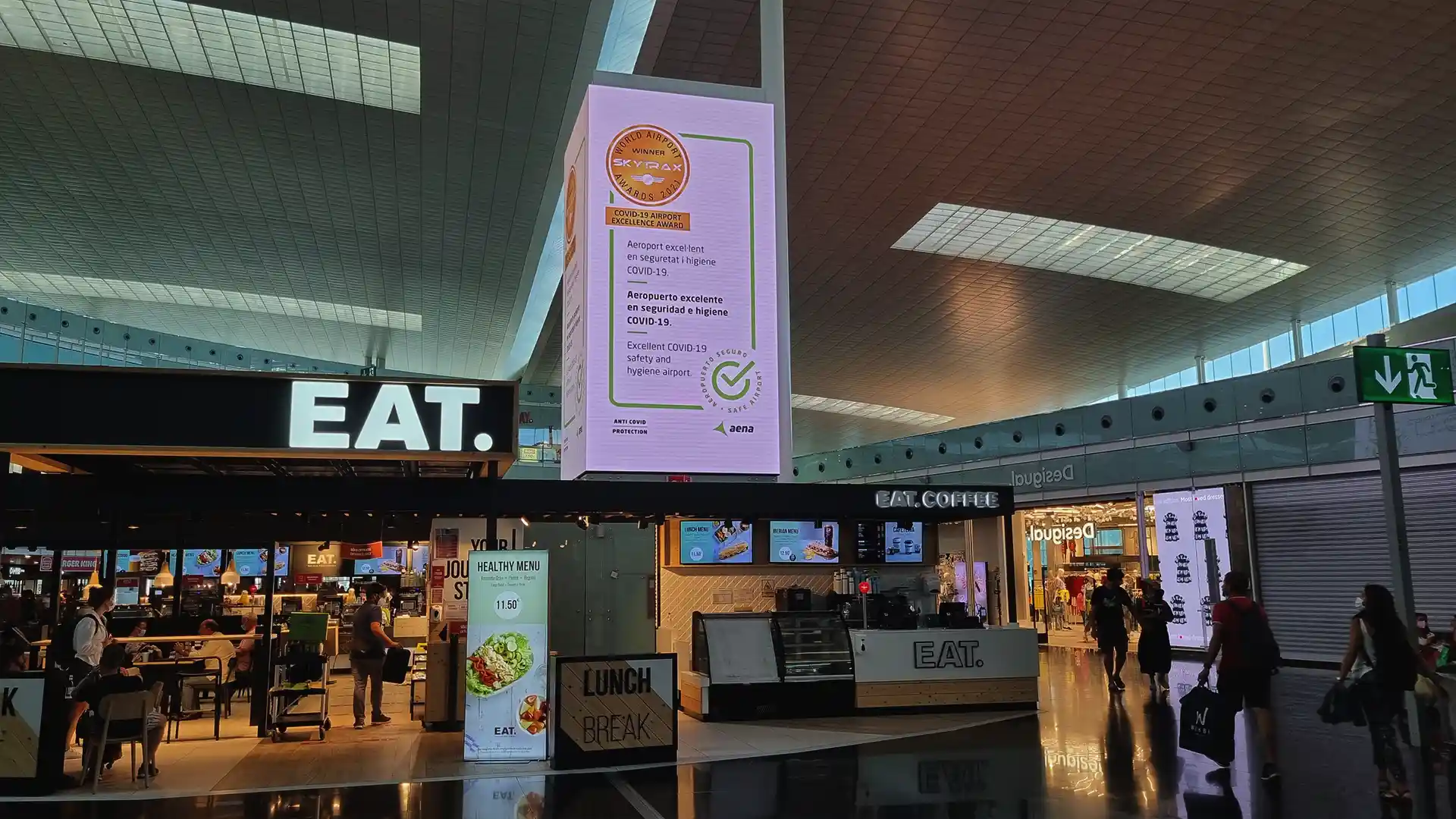 Vertical LED advertising cubes integrated into Barcelona–El Prat airport terminal architecture