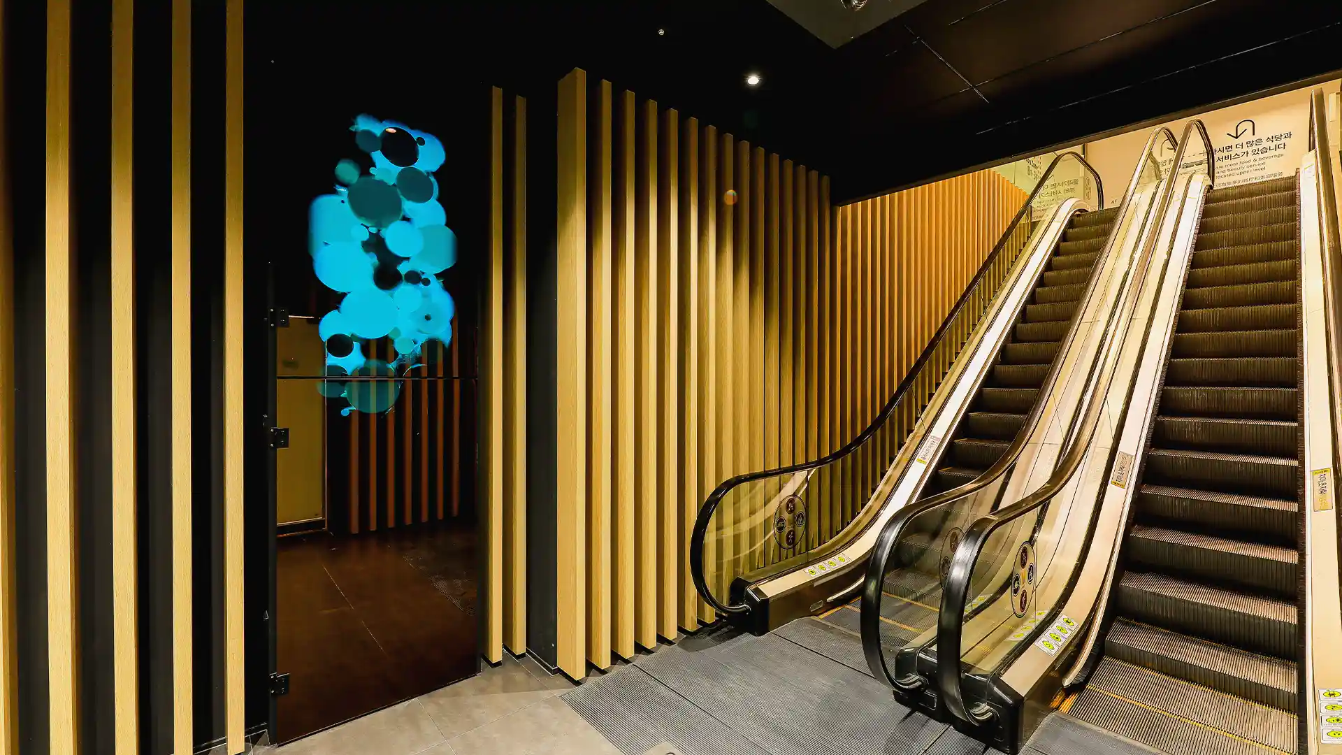 Digital architectural elements and warm materials integrated into the M Plaza entrance.